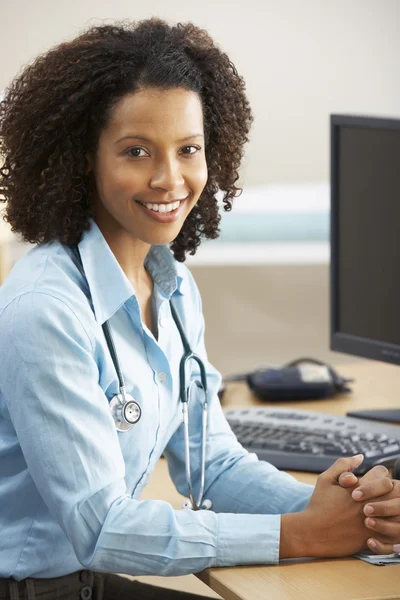 Young female Doctor sitting at desk — Stock Photo, Image