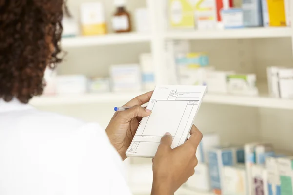 Enfermeira com prescrição em farmácia — Fotografia de Stock