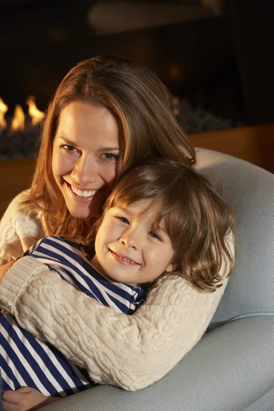 Mãe e filho sentados em frente ao fogo — Fotografia de Stock