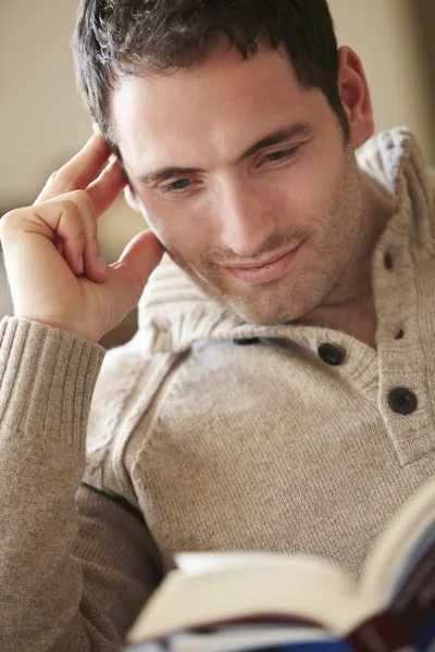 Young man reading book at home — Stock Photo, Image