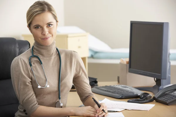 Female Doctor sitting at desk Stock Image