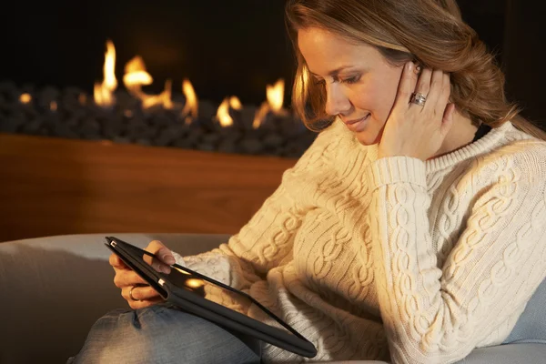 Ateşin önünde tablet kullanan kadın — Stok fotoğraf