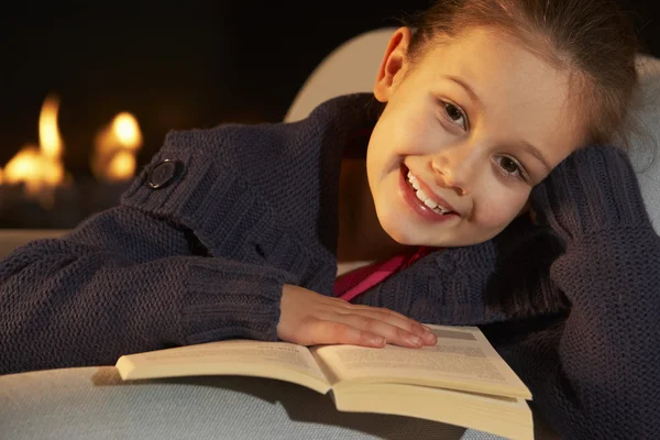 Chica leyendo por el fuego —  Fotos de Stock