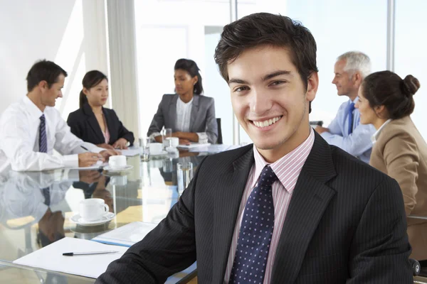 Zakenman met collega's bij de bestuurskamer — Stockfoto