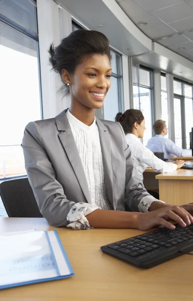 Travailleur souriant dans un bureau occupé — Photo