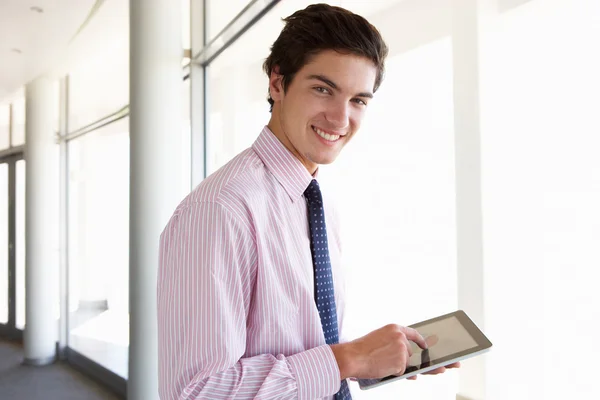 Empresário usando tablet digital no corredor — Fotografia de Stock