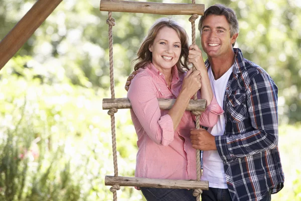 Paar ontspannen In de tuin door Treehouse — Stockfoto