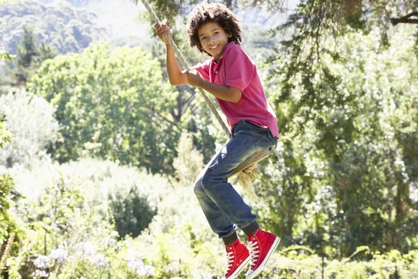 Joven chico tener divertido en cuerda swing — Foto de Stock