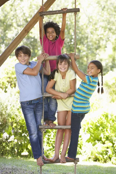 Niños escalando la escalera de cuerda a la casa del árbol — Foto de Stock