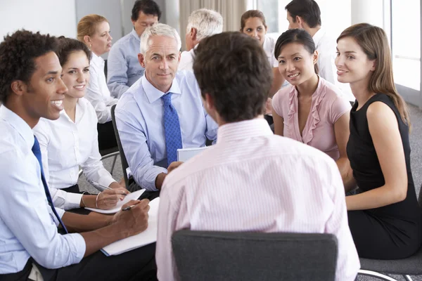 Geschäftsleute sitzen bei Firmenseminar im Kreis — Stockfoto