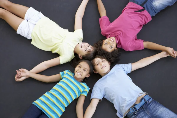 Niños acostados en trampolín juntos — Foto de Stock