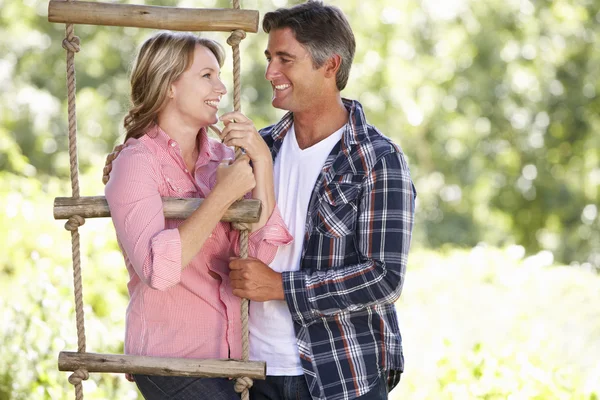 Pareja relajante en jardín por árbol — Foto de Stock