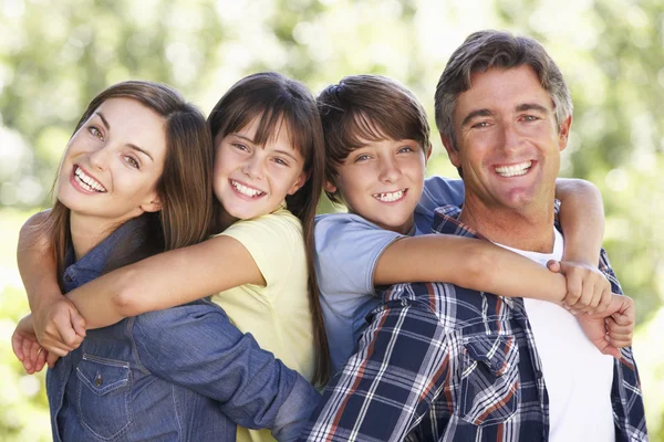 Bahçede gülümseyerek mutlu bir aile — Stok fotoğraf