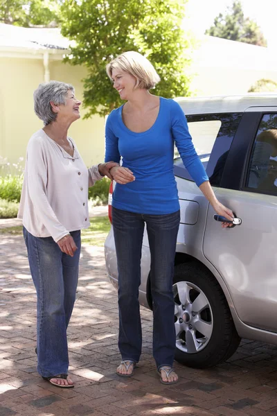 Woman Helping Senior Woman Into Car — ストック写真