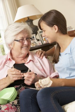 Grandmother Showing Granddaughter How To Crochet  clipart