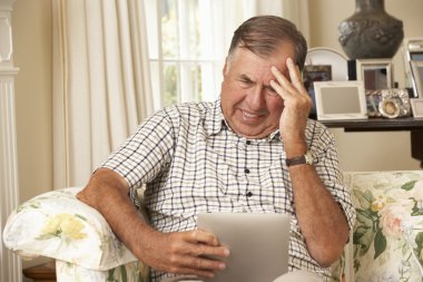 Frustrated Senior Man Using Digital Tablet  clipart