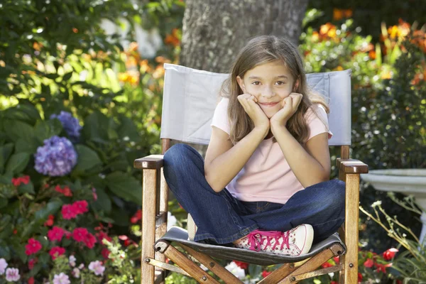 Niña sentada en el jardín — Foto de Stock