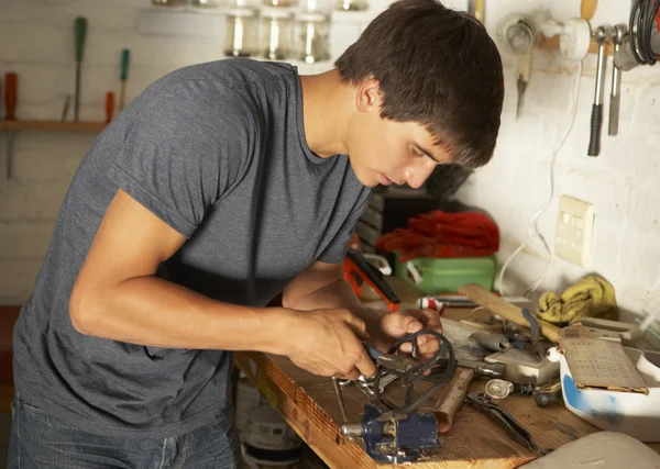 Ragazzo adolescente che utilizza il banco da lavoro in garage — Foto Stock