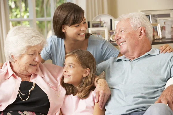 Nonni con nipoti seduti sul divano — Foto Stock