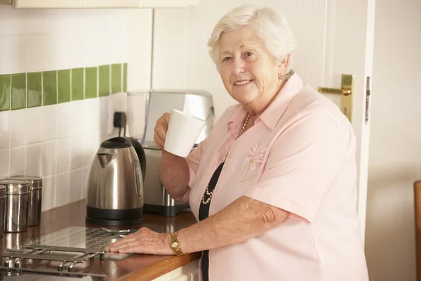 Seniorin macht Heißgetränk — Stockfoto