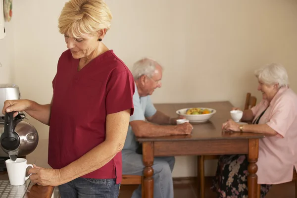 Home Helper With Senior Couple In Kitchen — ストック写真