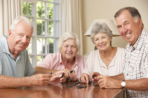 Coppie senior godendo del gioco del domino — Foto Stock