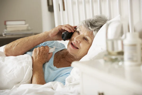 Больная старшая женщина разговаривает по телефону — стоковое фото