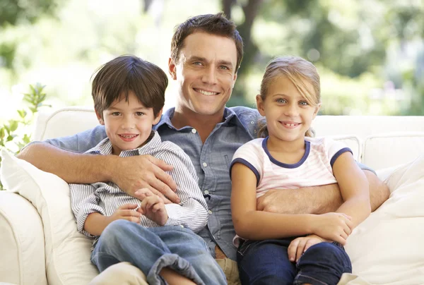 Pai e filhos sentados no sofá — Fotografia de Stock