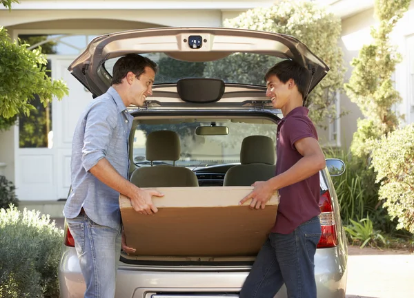 Father And Son Loading Package Into Car — Stockfoto