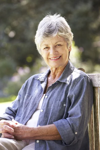 Senior kvinna avkopplande på parkbänk — Stockfoto