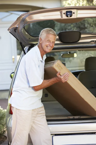 Starší muž načítání balíček do auta — Stock fotografie