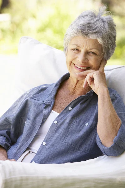 快乐的老年妇女坐在沙发上 — 图库照片