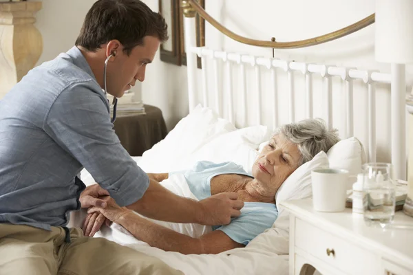 Доктор Обстеження старшого пацієнта в ліжку — стокове фото