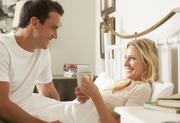 Муж приносит жене напиток в постель — стоковое фото
