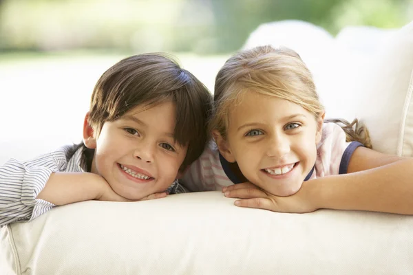 Deux enfants se relaxent sur le canapé — Photo