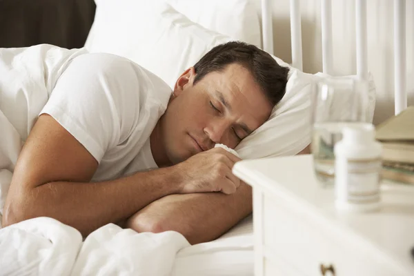 Az alvó ember éjjeliszekrény gyógyszeres kezelés — Stock Fotó