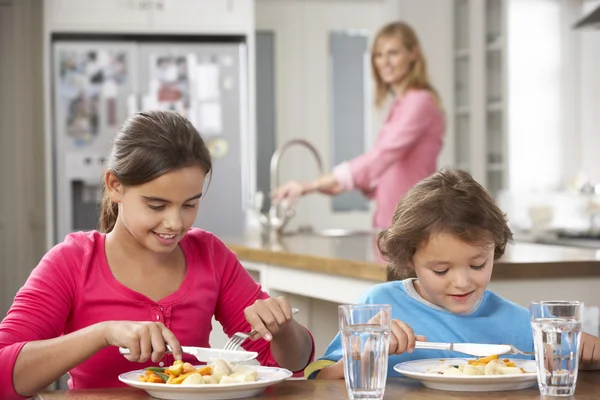 Enfants avec mère ayant des repas dans la cuisine — Photo