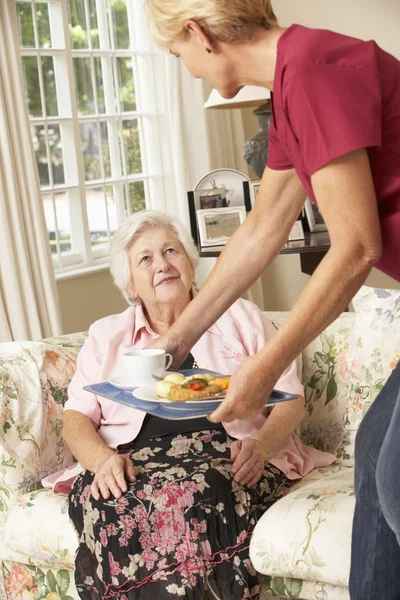 Helper Serving Senior Woman With Meal Royalty Free Stock Photos