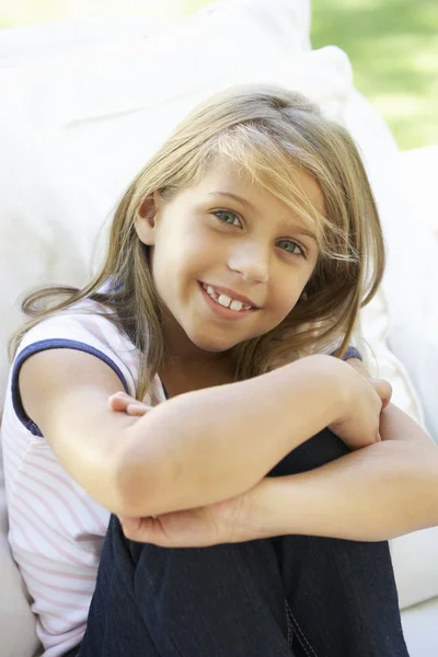 Молодая девушка сидит на диване Стоковое Фото