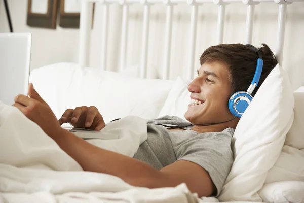 Teenage Boy Using Laptop And Headphones — Stock Photo, Image