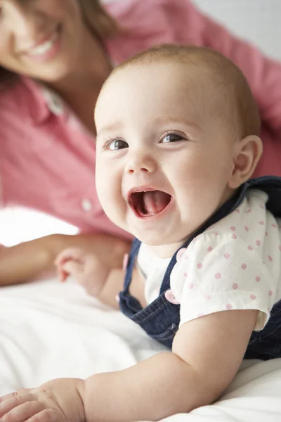 Mãe com bebê menina brincando na cama — Fotografia de Stock