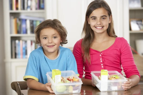 Due bambini con sani cestini da pranzo in cucina — Foto Stock