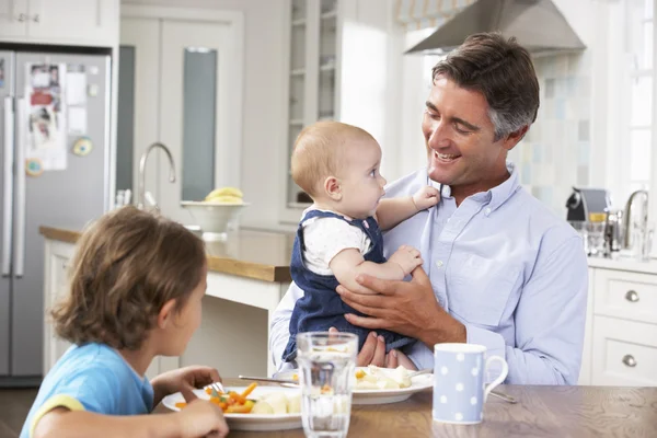 Vader en kinderen maaltijd In keuken — Stockfoto
