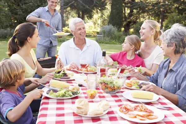 Family Enjoying Barbecue In Garden — Stock fotografie