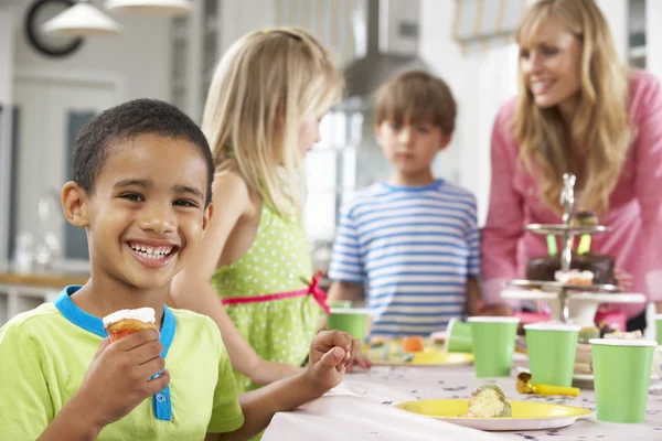 Kinderen genieten van verjaardag partij voedsel aan tafel — Stockfoto