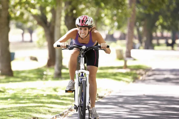 Жінка велосипеді через парк — стокове фото