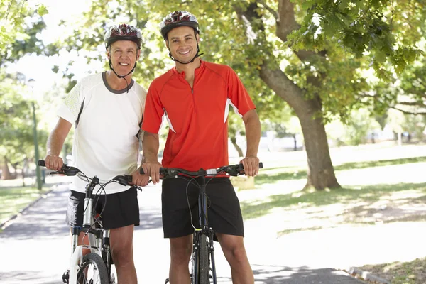 Due uomini in bicicletta attraverso il parco — Foto Stock