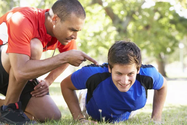 Junger Mann arbeitet mit Personal Trainer — Stockfoto