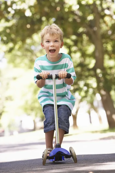 Jovem menino no scooter no parque — Fotografia de Stock