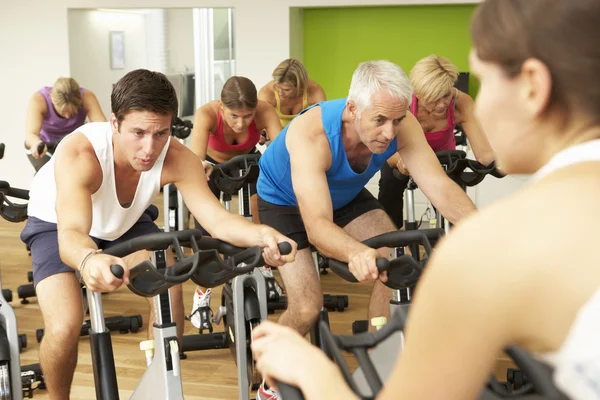 Grupo de personas haciendo ejercicio en la clase de spinning — Foto de Stock